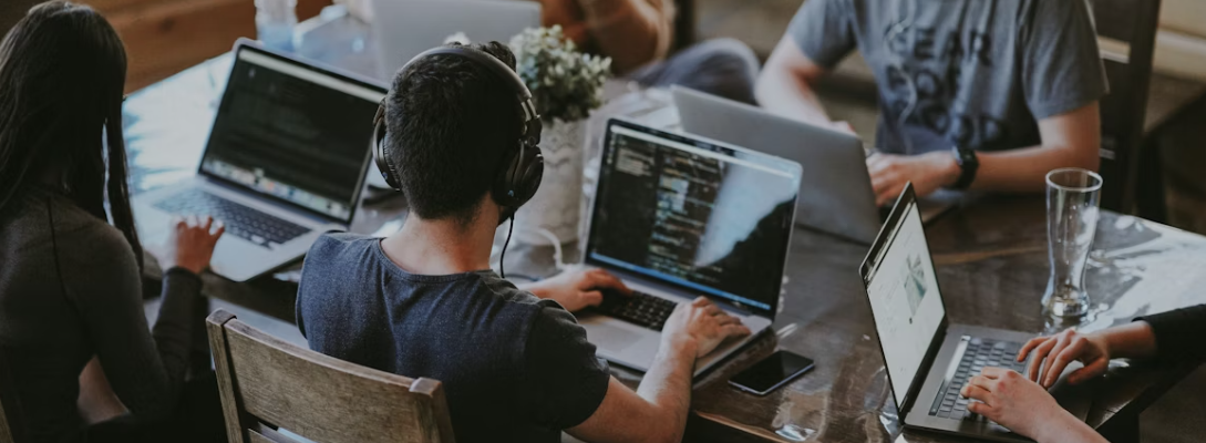 A team working on laptops around a table