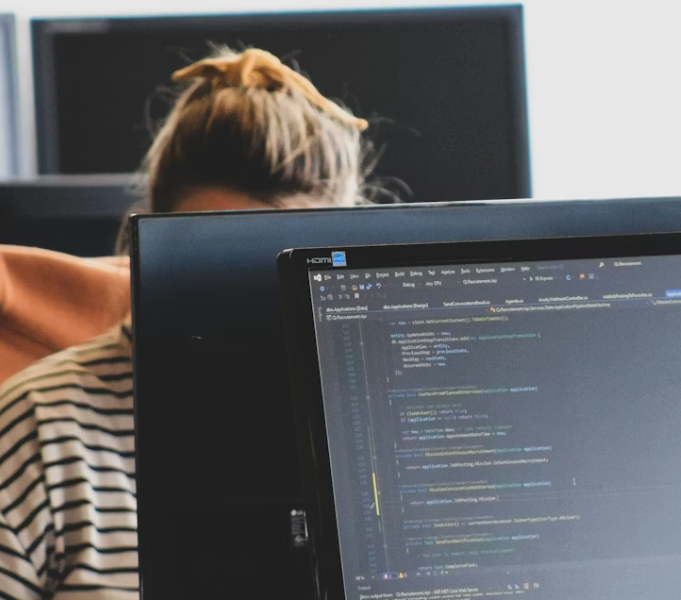A developer working on code on a monitor